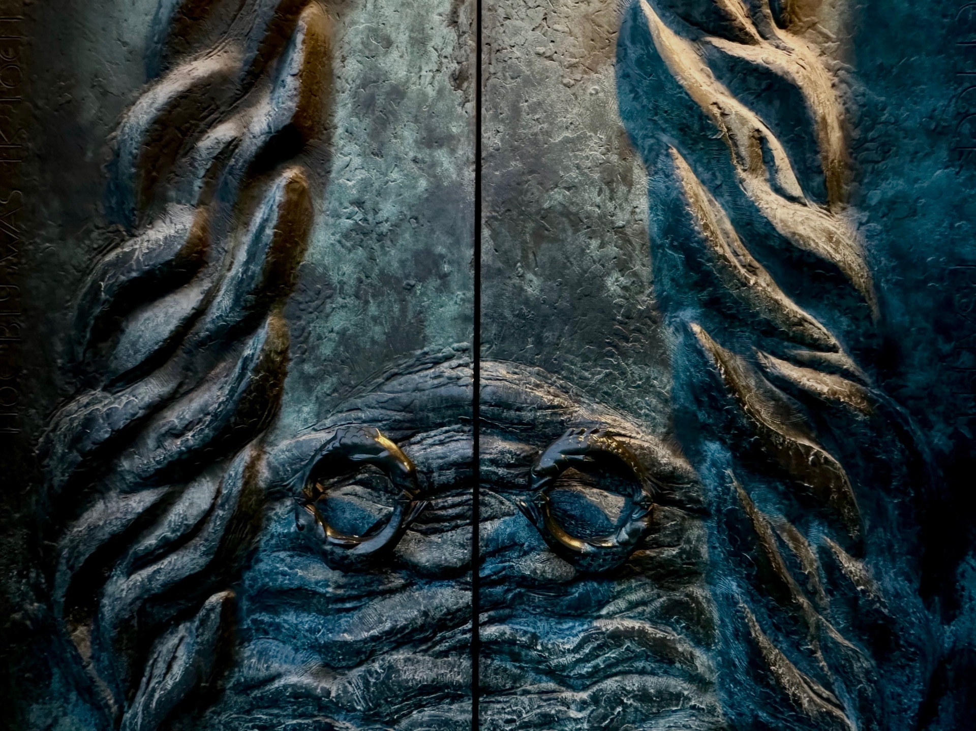 Patinated bronze doors with deep green and bronze relief